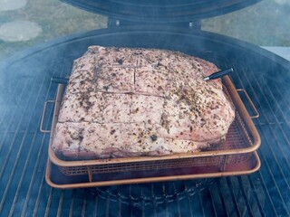 Pork shoulder smoked on a charcoal grill for pulled pork