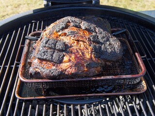 Pork shoulder smoked on a charcoal grill for pulled pork