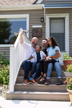 Family Taking a Joyful Selfie on Porch Steps