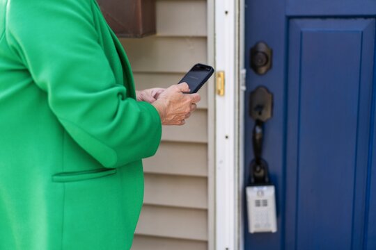 Real Estate Agent Unlocking Door with Smartphone