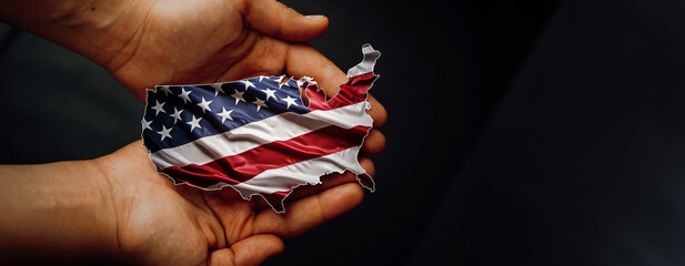 Male hands holding Flag of the United States of America, shape of the USA map. Photo for presidential election 2024, People will decide the future of America. Black edit space, panoramic format