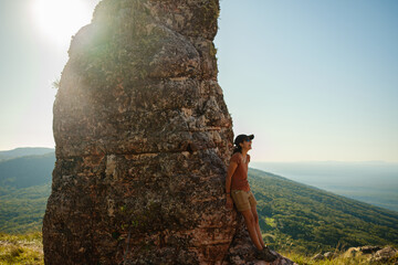 adventurous woman walking along the edge of a mountain
