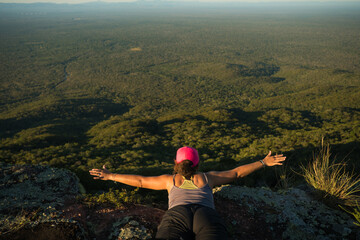 travel woman with arms outstretch on the mountain edge