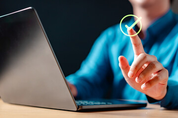 checkmark, check, approve, finger, laptop, technology, job, keyboard, search, hands. A person is using a laptop and pressing a button with a check mark on it. Concept of accomplishment or satisfaction