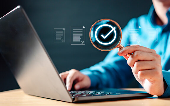 system, innovation, typing, technology, iot, future, job, social, management, marketing. A person is holding a magnifying glass over a laptop screen. The laptop screen shows a check mark.