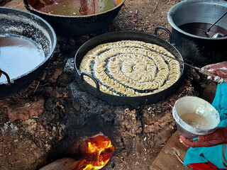 Cooking process of village sweet with wooden fuel in village fair of bangladesh