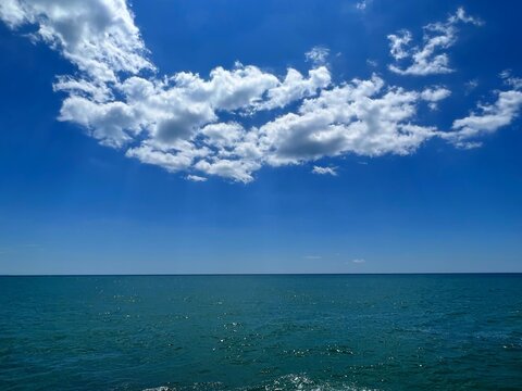 Blue sea and sky with clouds.