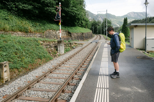 teen boy waiting  for train during a backpacking trip