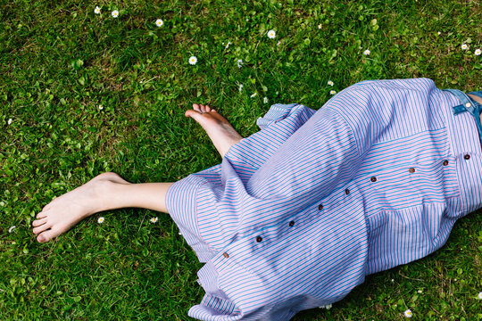 Crop woman lying on grass