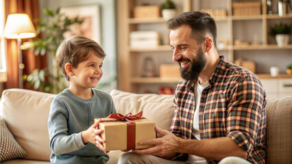 father and son with gift box sitting on sofa in living room at home