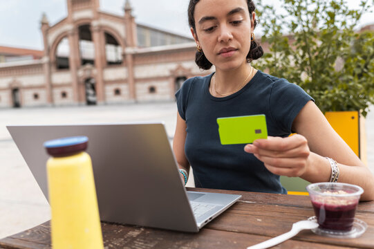 Entrepreneur processing online payment with laptop and credit card
