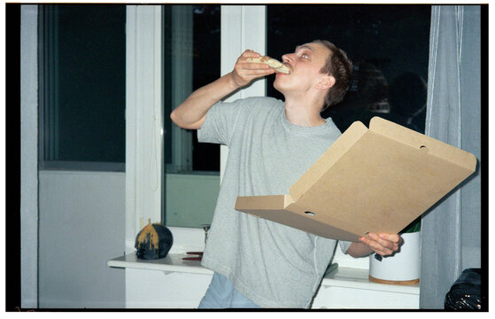 guy energetically eating a slice of pizza