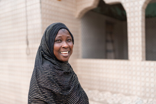 Senegalese woman smiling in front of house in africa