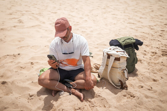 Man on the beach without battery in his cell phone
