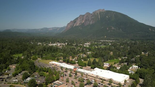 Aerial above shops in North Bend Washington in summer below Mount Si