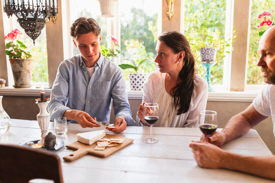 Family Enjoying Wine and Cheese Together at Home in the Evening