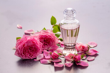 Bottles of essential rose oil and flowers