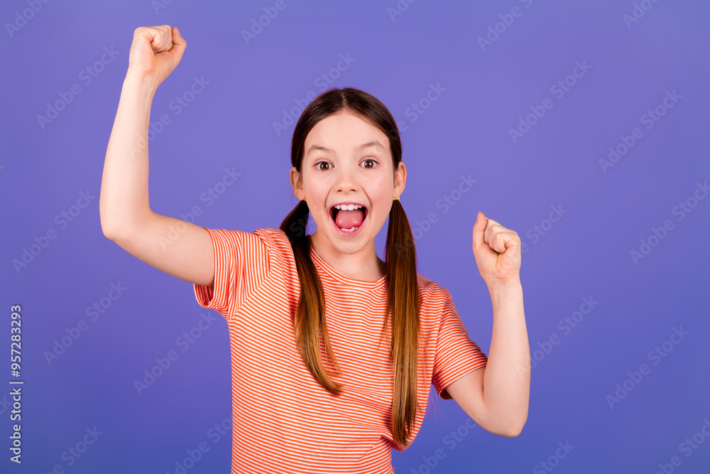 Wall mural Photo portrait of lovely small girl raise fists winning dressed stylish red garment isolated on violet color background