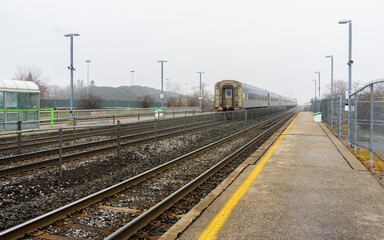 Train passing through a station on a foggy winter day in Toronto, Canada