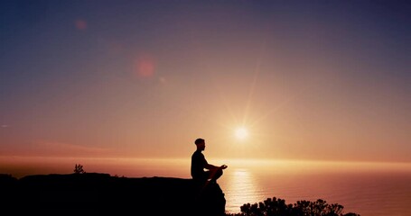 Person, meditation and silhouette on mountain at sunset with mindfulness, lotus and mock up space in sky. Breathing, sunshine and outdoor on cliff with zen balance, yoga and ocean in New Zealand