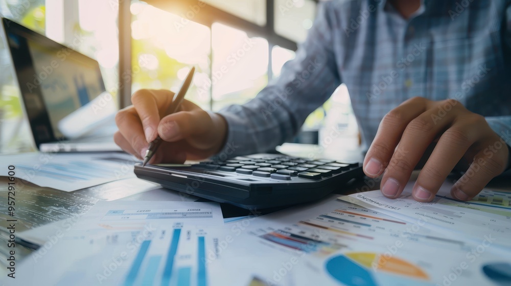 Aufkleber business professional calculating financial data with calculator and analyzing graphs in office