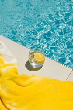 Close-up of a glass cup with a lemon drink  placed next to a pool