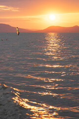 beautiful sunset over Lake Balaton with a woman windsurfing