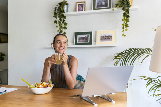 Healthy woman with kombucha at home office desk, quality time