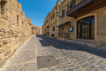 Azerbaijan stare miasto İçərişəhər w Baku. Stare mury obronne, zabytkowa uliczka z starymi drewnianymi balkonami © smoku7979