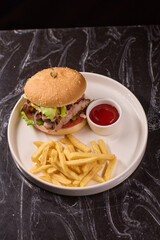 A Delicious Burger served with Crispy Fries and a side of Ketchup on a Dark Marble Table