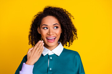 Photo of ecstatic woman with perming coiffure dressed stylish shirt look at proposition empty space isolated on yellow color background