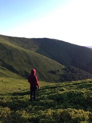 Fototapeta premium person in red hoodie walking on a mountain