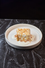 Enjoy a delicious dessert with caramel swirls elegantly presented on a white plate