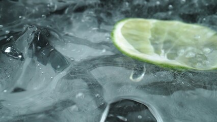 Macrography, witness the mesmerizing allure of a margarita bubble delicately adorned with a slice of lime, set against a bold black background. Each close-up shot of cocktail with lime. Comestible.