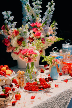 Elegant Floral Table Setting with Berries And Sweets

