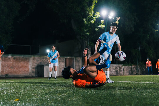 Football player falling after a tackle.