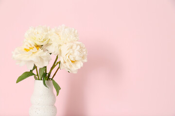 Vase of white peonies on pink background