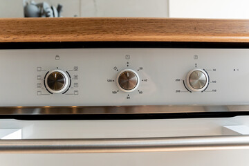 A closeup of a stainless steel oven with three knobs
