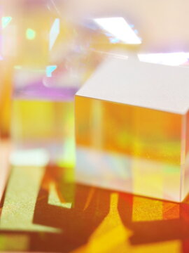 A cube is sitting on a table with a yellow background