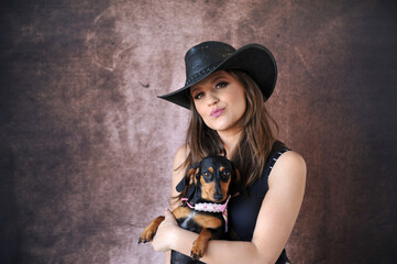 mulher vaqueira com chap&eacute;u e cachorro fofo