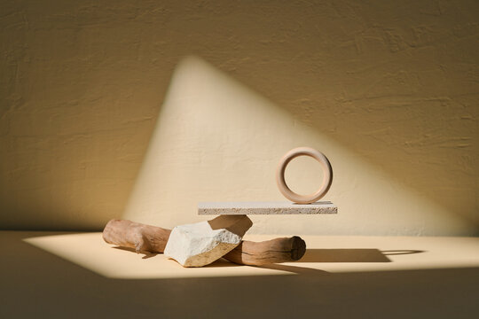 Balancing Wooden Circle on Rock and Logs with Sunlight