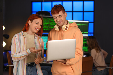 Young programmers working with laptop in office at night