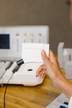 Hand holding a medical dermoanalyzer for skin study in pharmacy