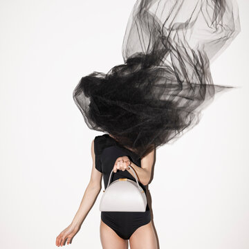 Fashion Model Posing with White Handbag and Flowing Fabric