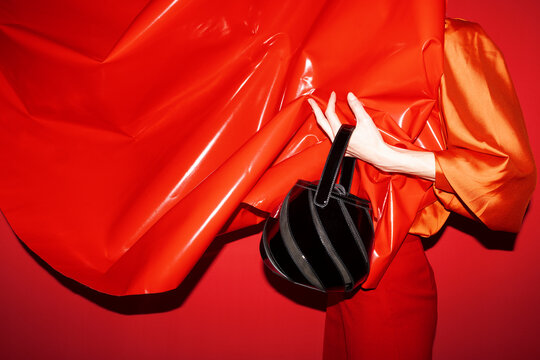 Stylish Fashion Model with Black Handbag and Red Fabric