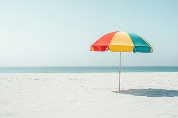 Bright multicolored umbrella on serene beach.