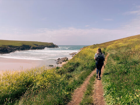 Female walking the coast path above Porth Joke in Cornwall