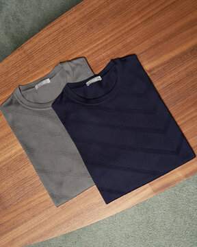 Two Striped Shirts on Wooden Table
