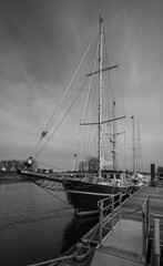 picture of a sailing ship on a pier in a little river