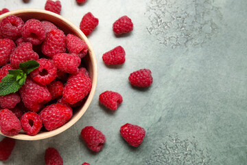 Bowl with fresh raspberry and mint on light background, closeup